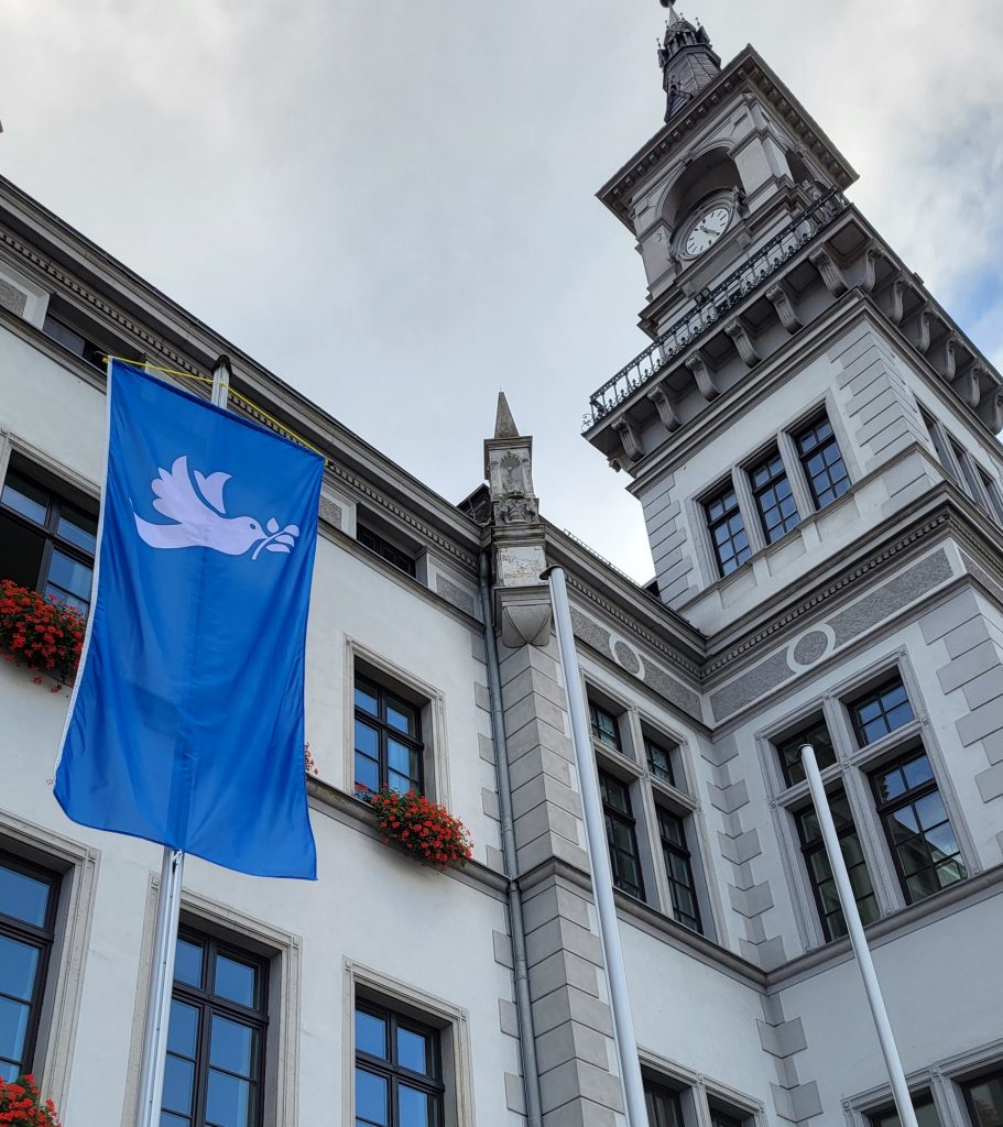 Friedenstaube: Fahne weht vor dem Rathaus - Ulrich Lupart